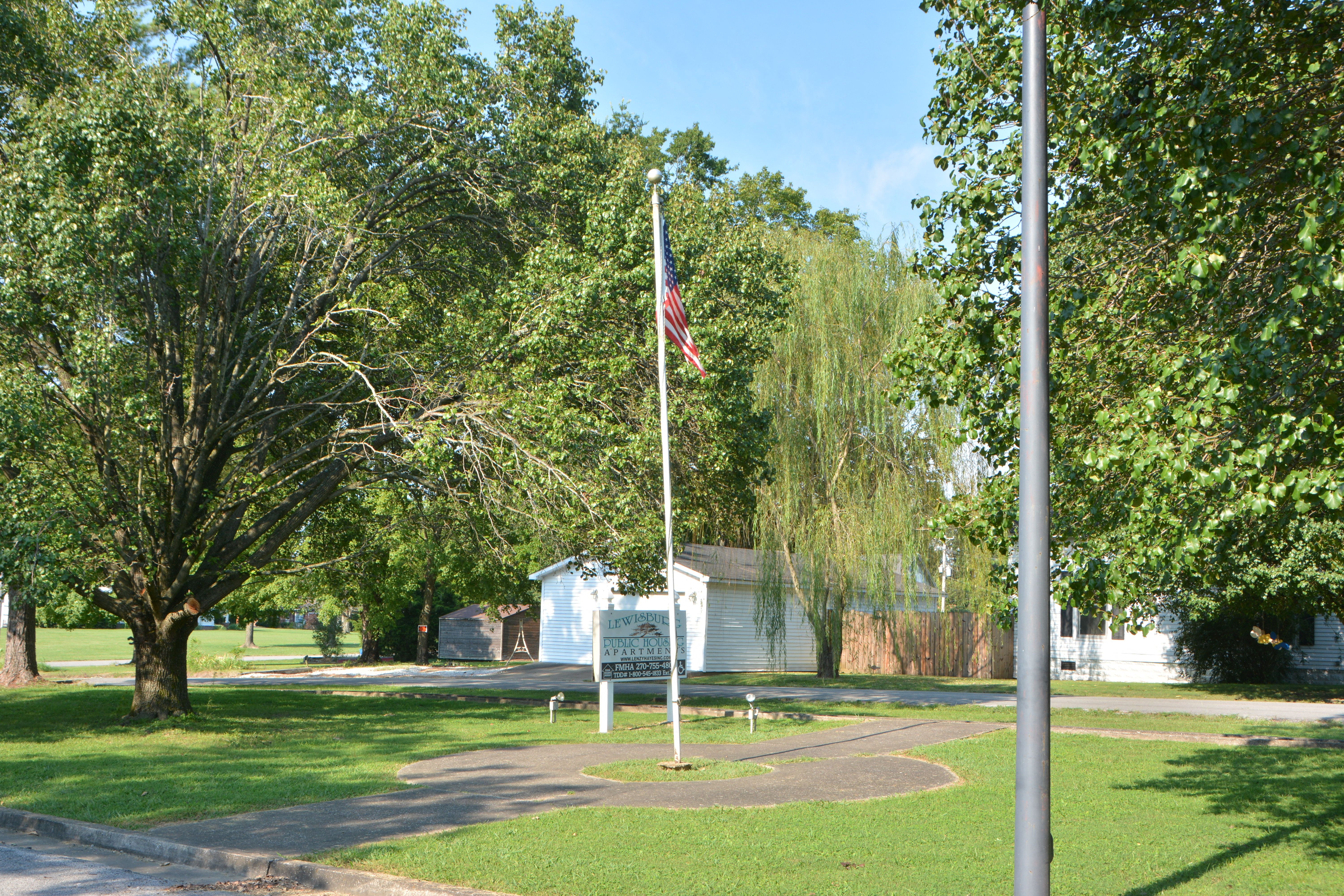 a flag pole with an flag in a park
